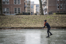 910704 Afbeelding van een schaatser op een bevroren Stadsbuitengracht ter hoogte van de Catharijnesingel te Utrecht.